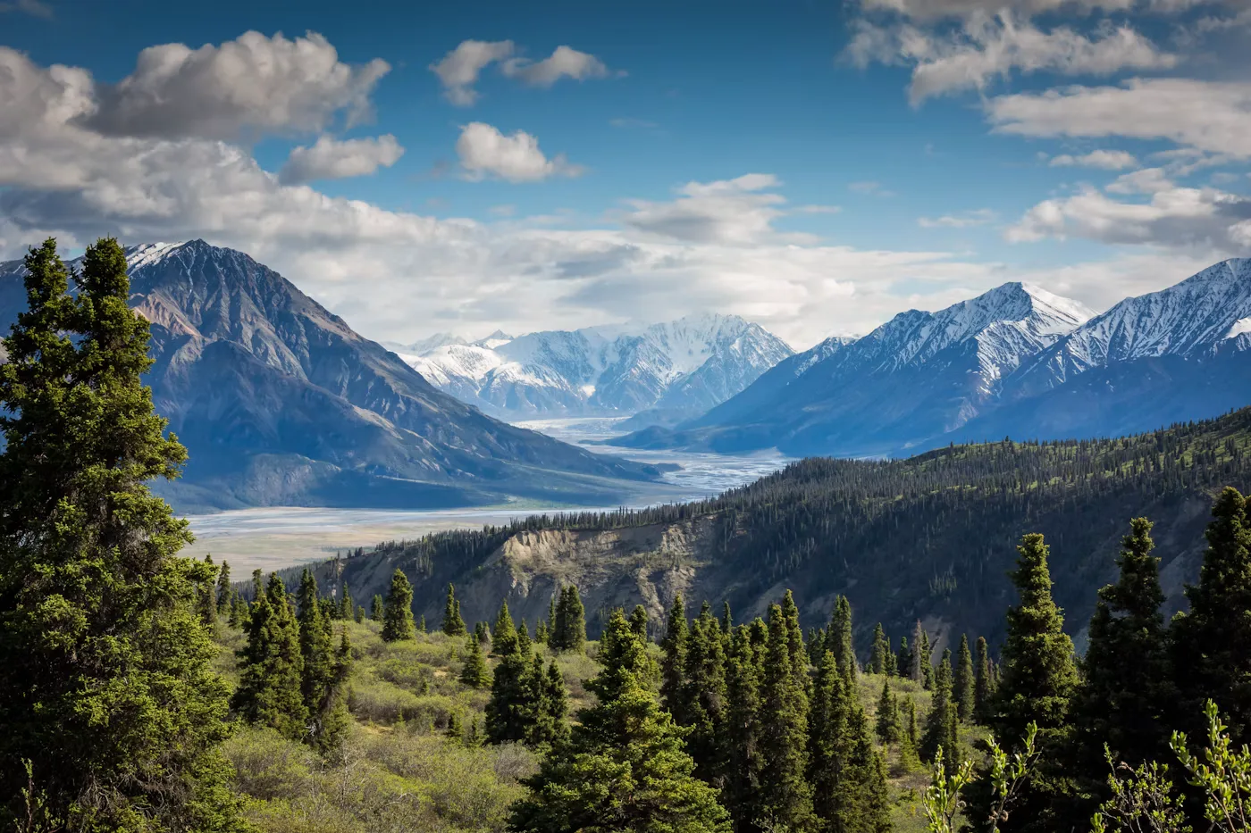 Rocky mountain peaks rising above a forested alpine valley