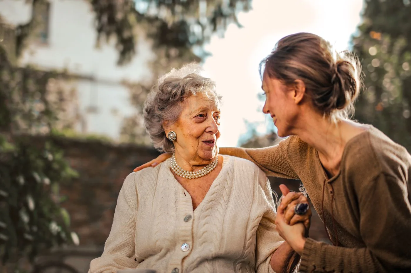 Older woman supported by a family member outdoors